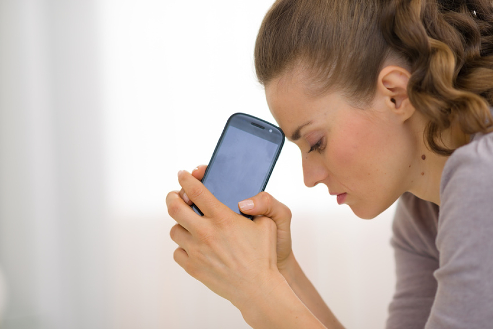 Portrait of stressed young woman with cell phone