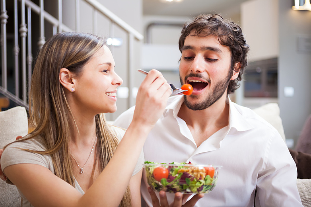 Couple eating a salad in the living room