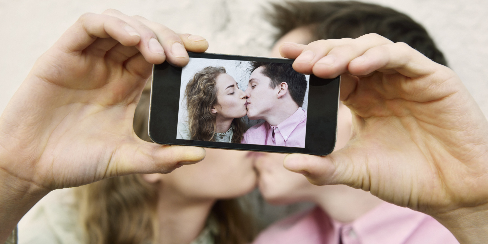 Couple photographing themselves kissing.