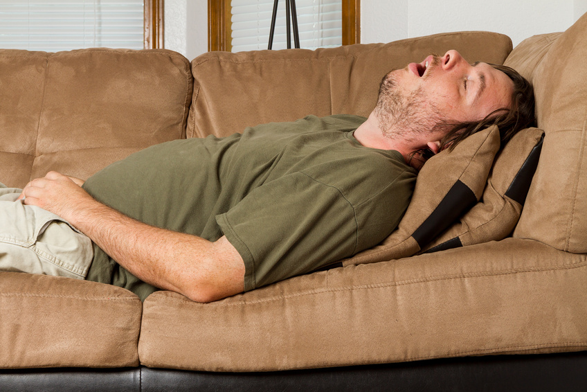 Man asleep on the couch with his mouth wide open.